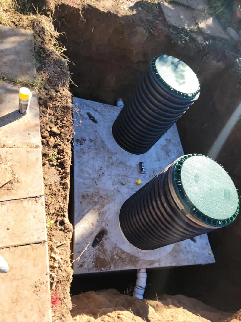 New concrete septic tank with two risers in an open excavation
